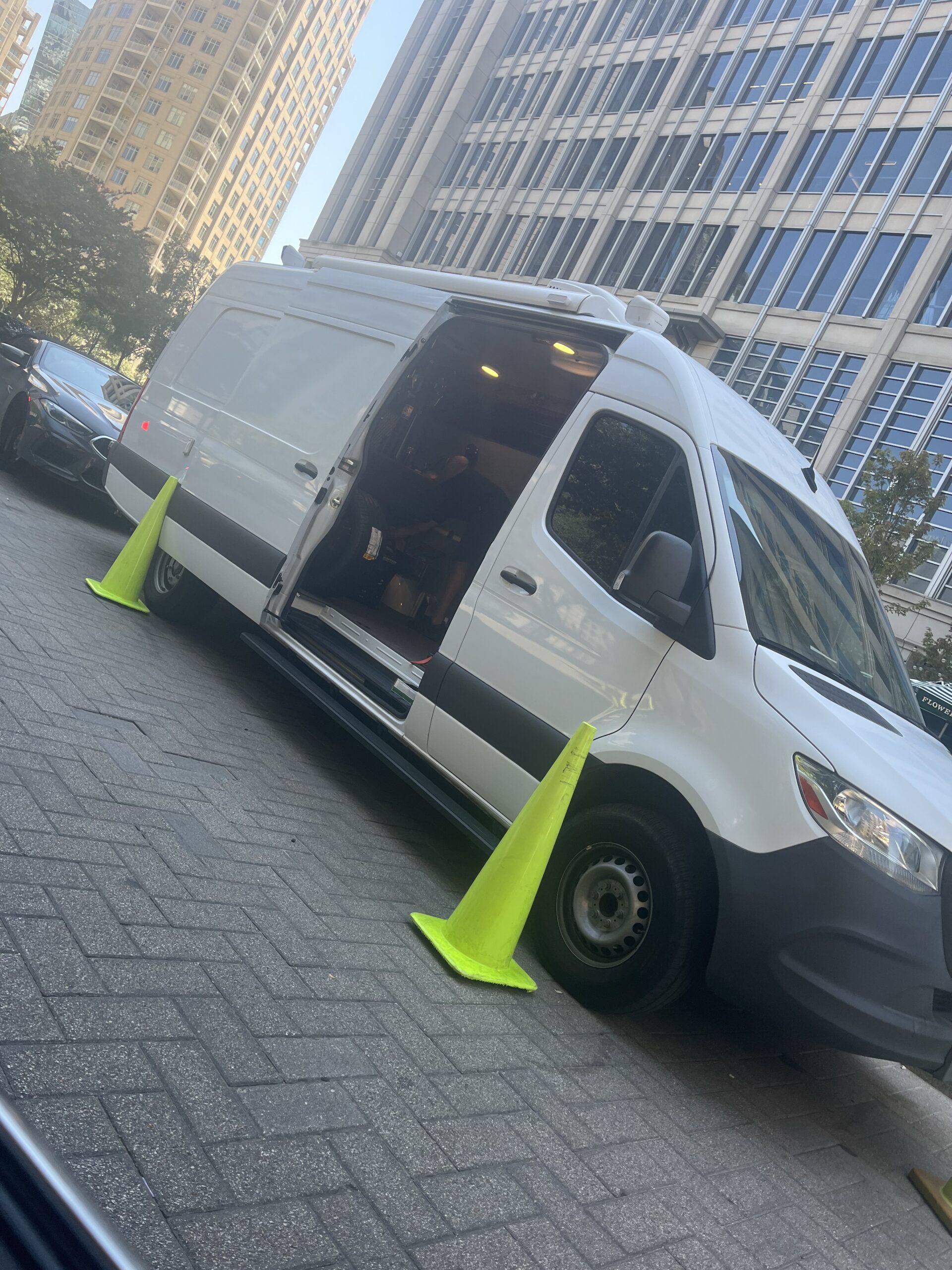 Supreme Mobile Tire service van performing a tire replacement on the roadside in downtown Dallas.
